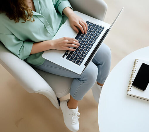 Kobieta z dłońmi na klawiaturze laptopa